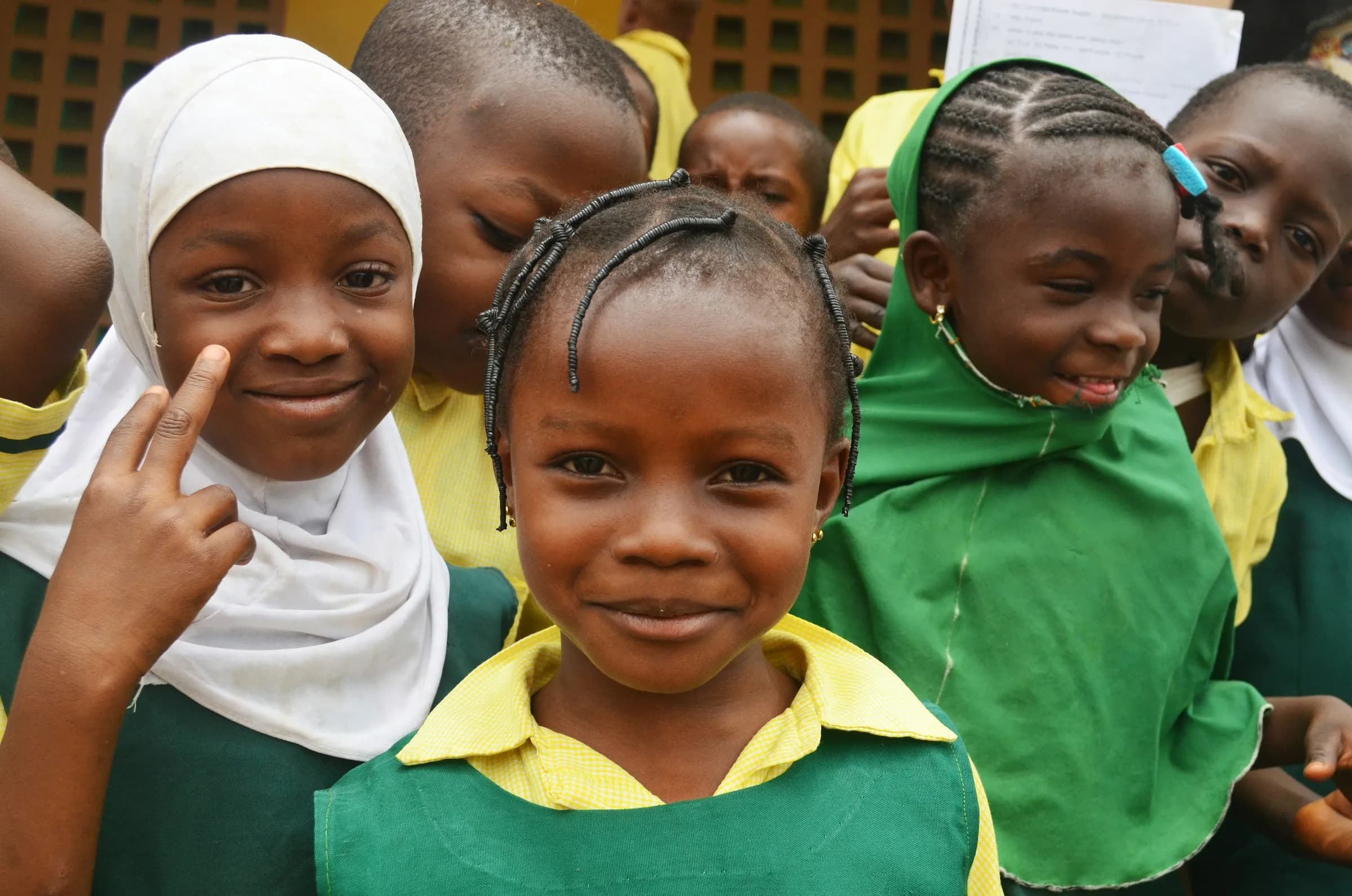 Smiling Nigerian schoolgirls in green and yellow uniforms